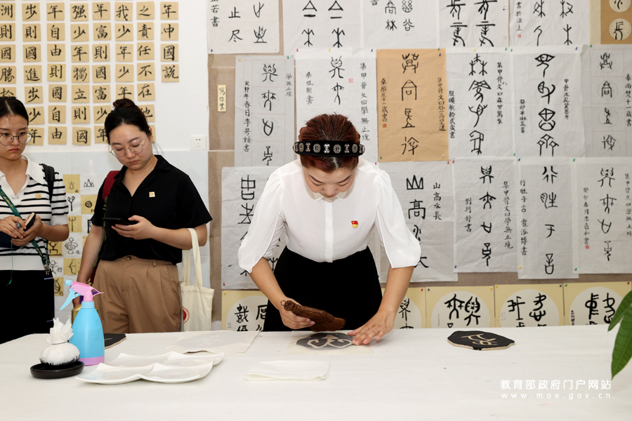 安阳市中华园小学教师在甲骨文社团教室展示甲骨文的拓印过程。据了解，该校设有甲骨文社团，定期组织学生进行甲骨文书法习练、绘画、拓印等活动，旨在从丰富多彩的实践中提高孩子们的学习兴趣，加深对甲骨文的认识。（许怡 谢沂楠/文 张劲松/摄）